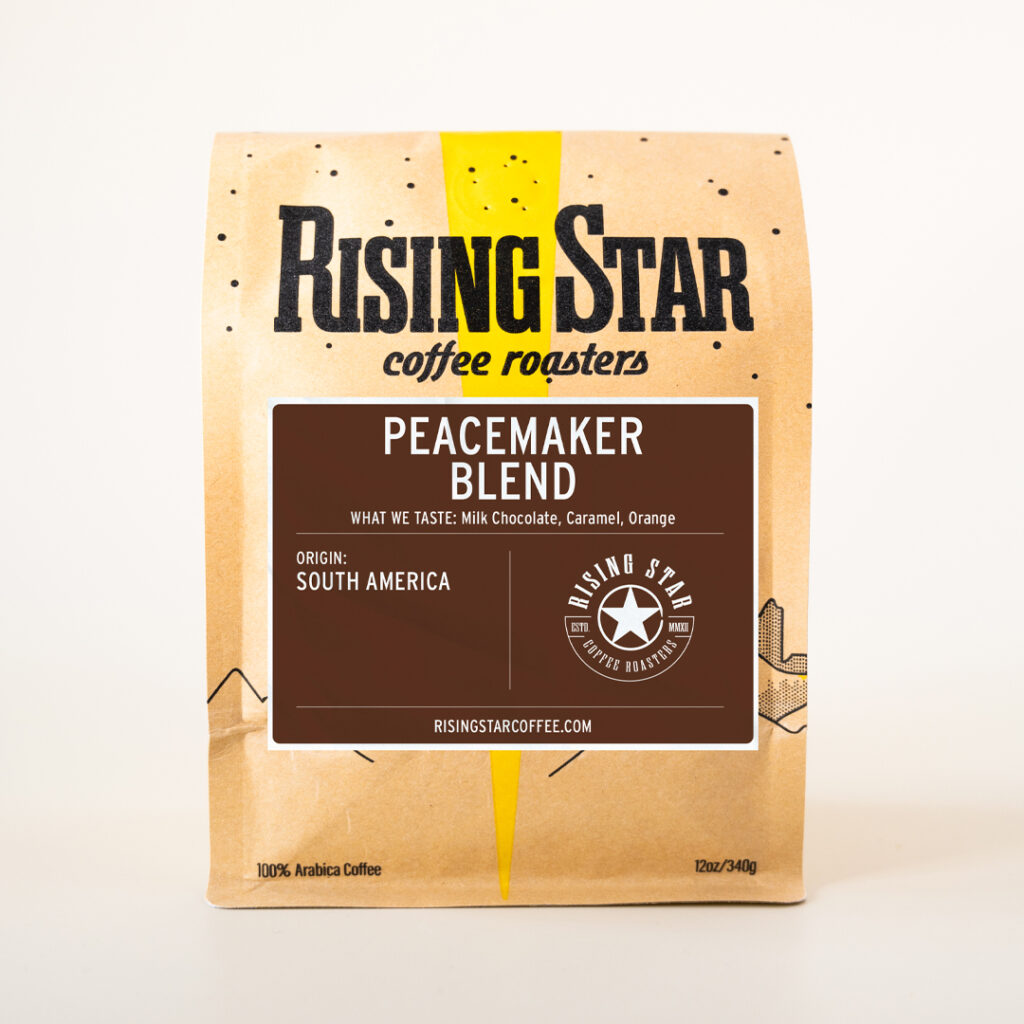 A bag of Rising Star Coffee's Peacemaker Blend set in front of a cream colored background.