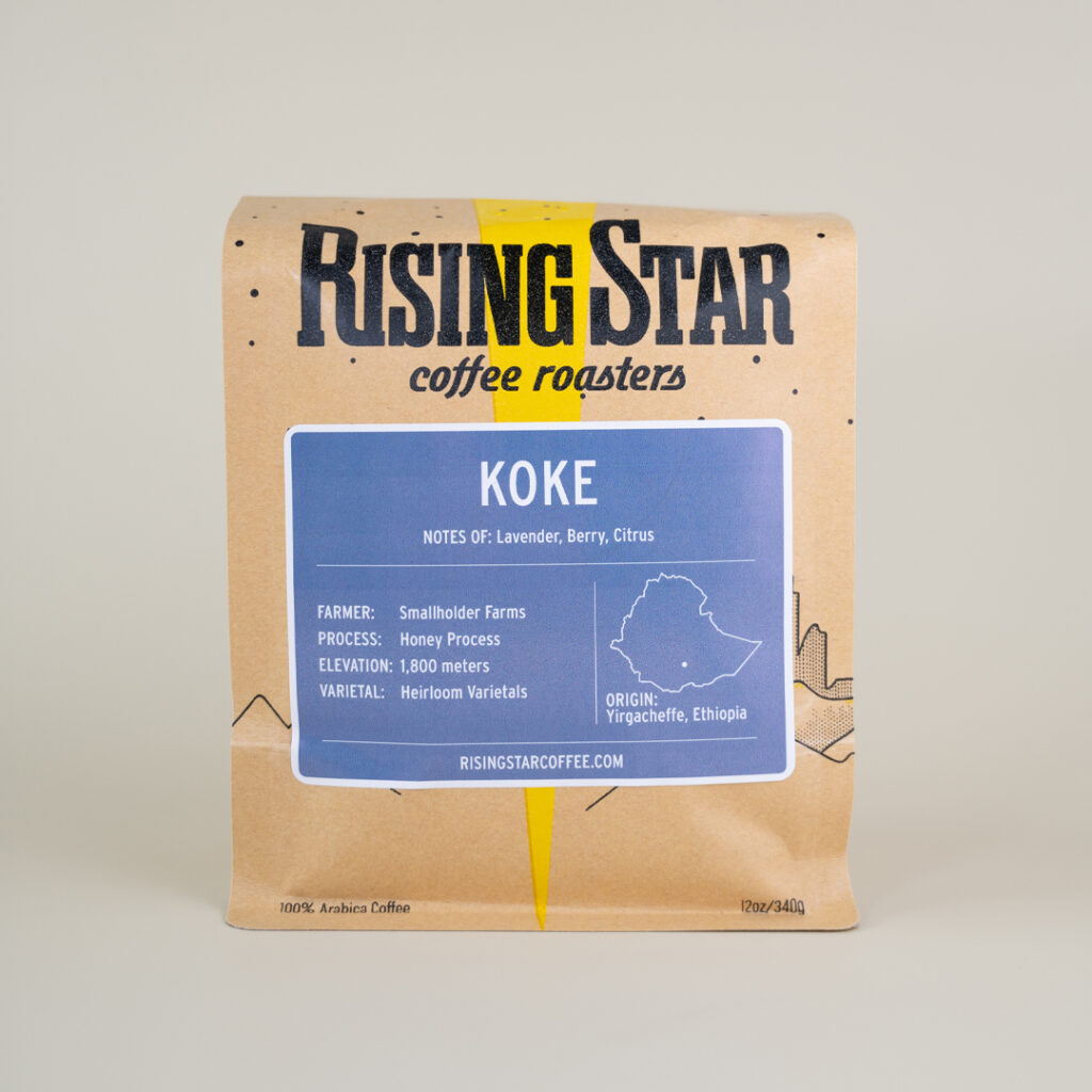 A bag of Rising Star Coffee with a lavender colored label that reads Koke. It is an Ethiopian coffee with notes of Lavender, Berry, and Citrus.