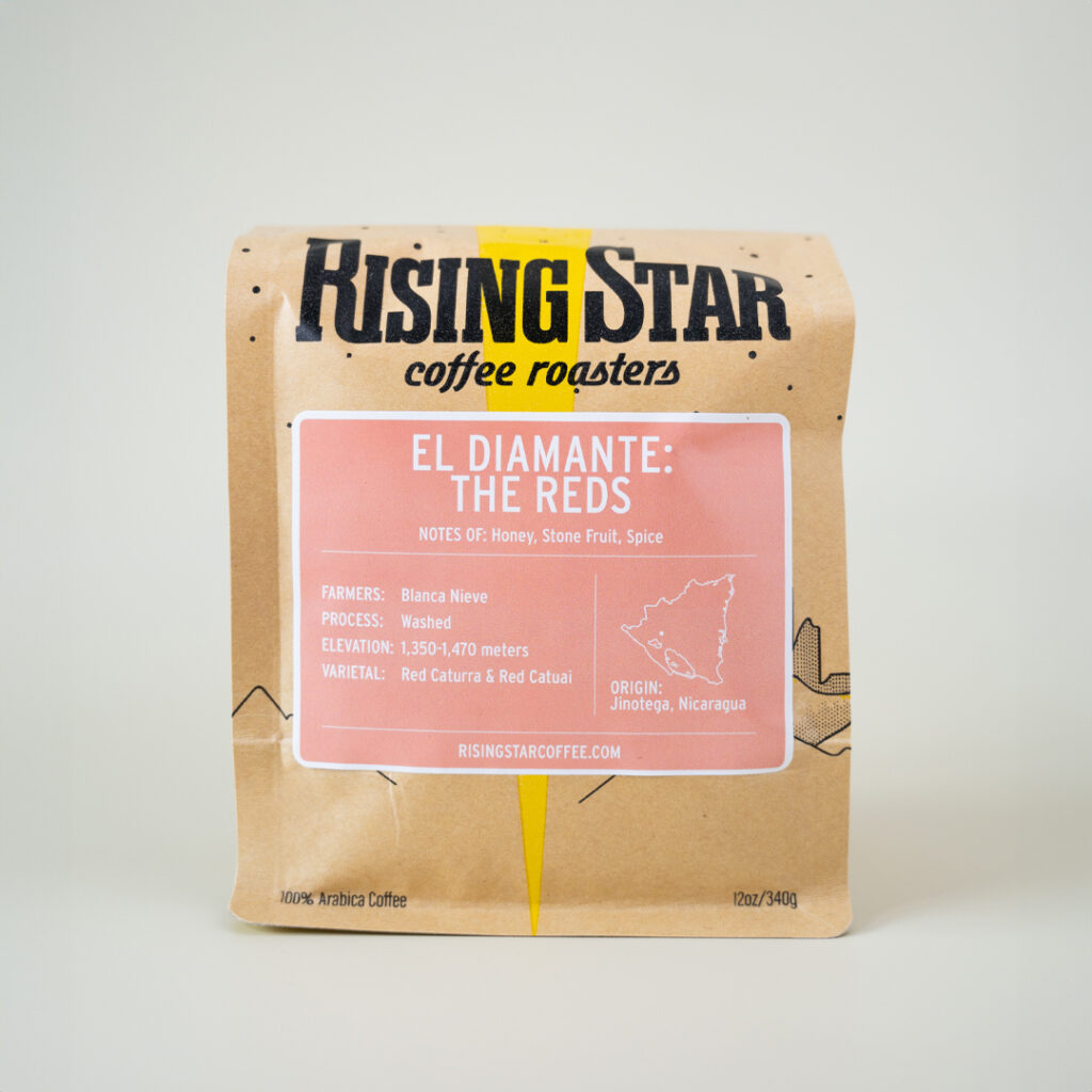 A bag of Rising Star coffee with a pinky peach label that reads "El Diamante: The Reds"