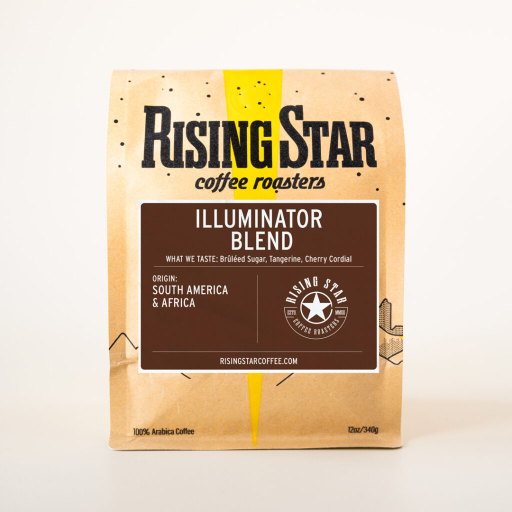 A bag of Rising Star Coffees Illuminator Blend. The label is brown with the region being South America and Africa. The notes are Bruleed Sugar, Tangerine, and Cherry Cordial.