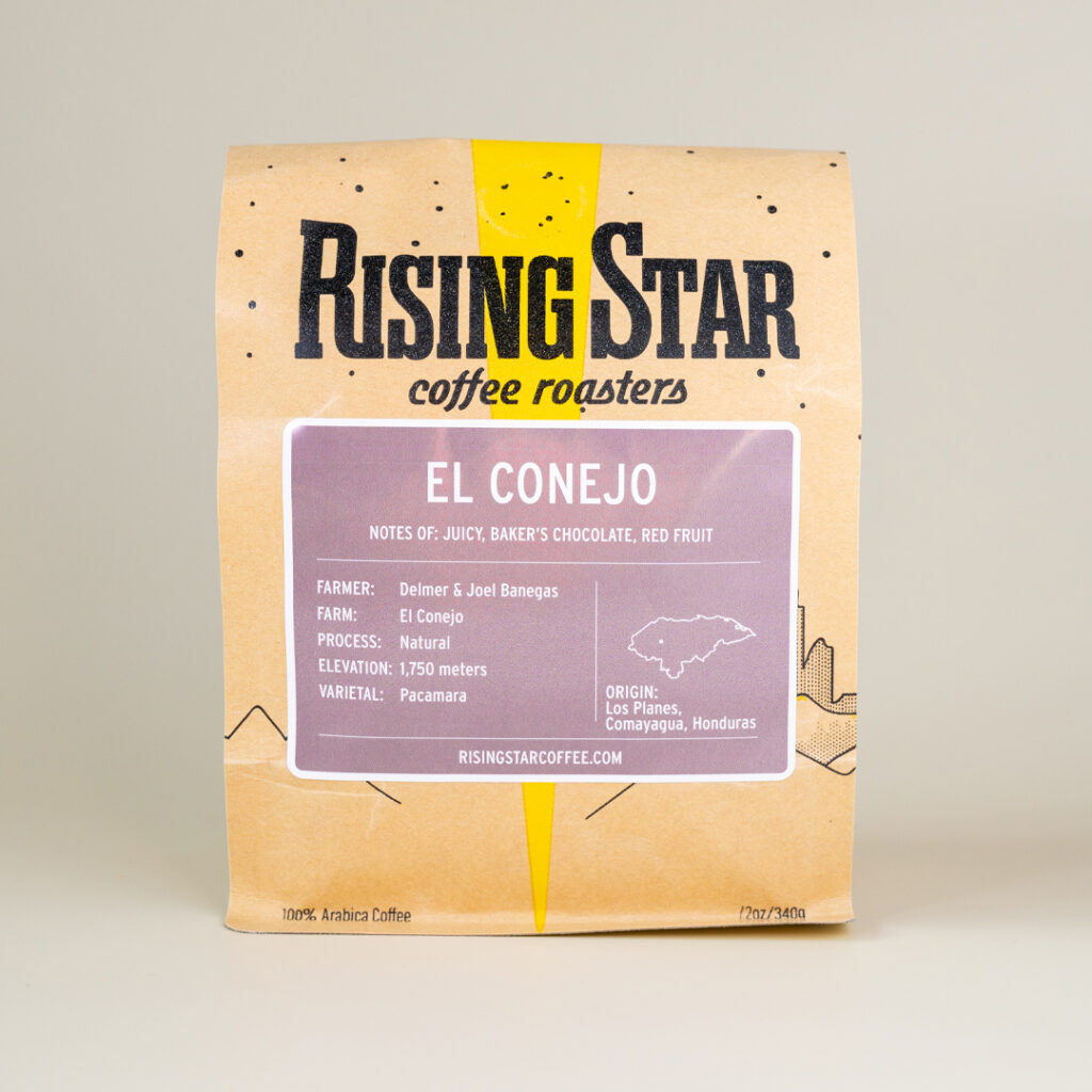 A bag of Rising Star Coffee beans. The faint purple label reads: "El Conejo".