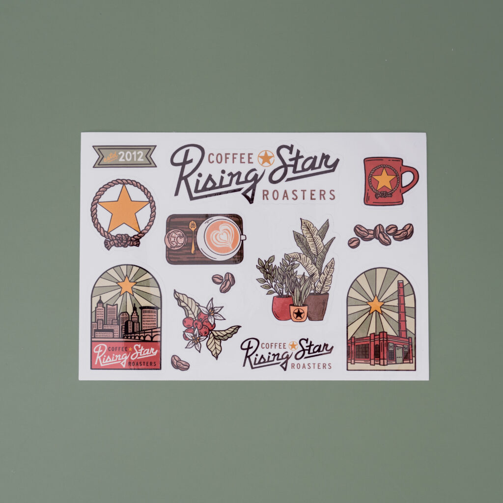 A sticker sheet featuring the artwork of Lisa Quine. The sheet features: house plants, the Hildebrandt building, coffee plants, a coffee mug, and a latte set up.