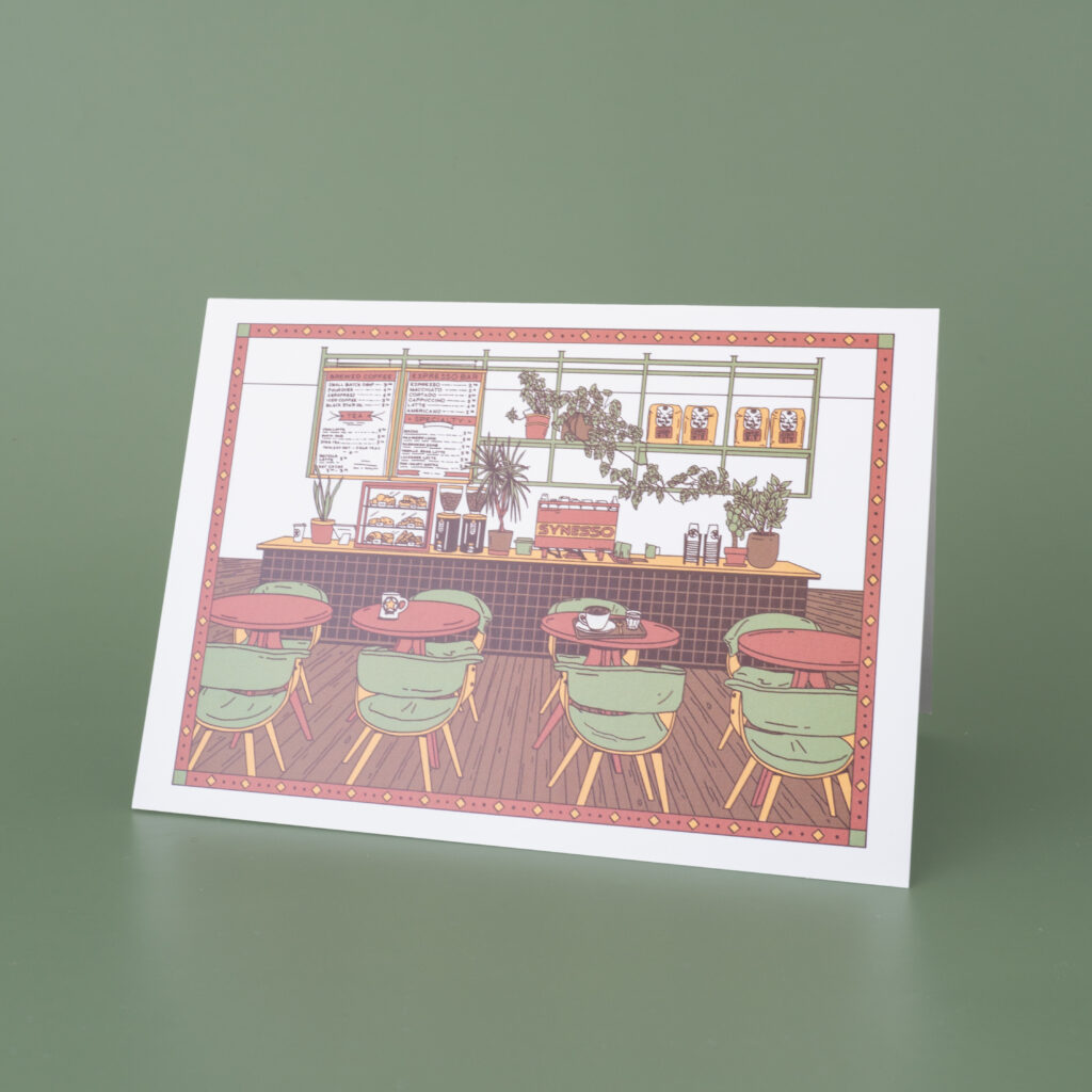 A greeting card with artwork featuring a cafe.