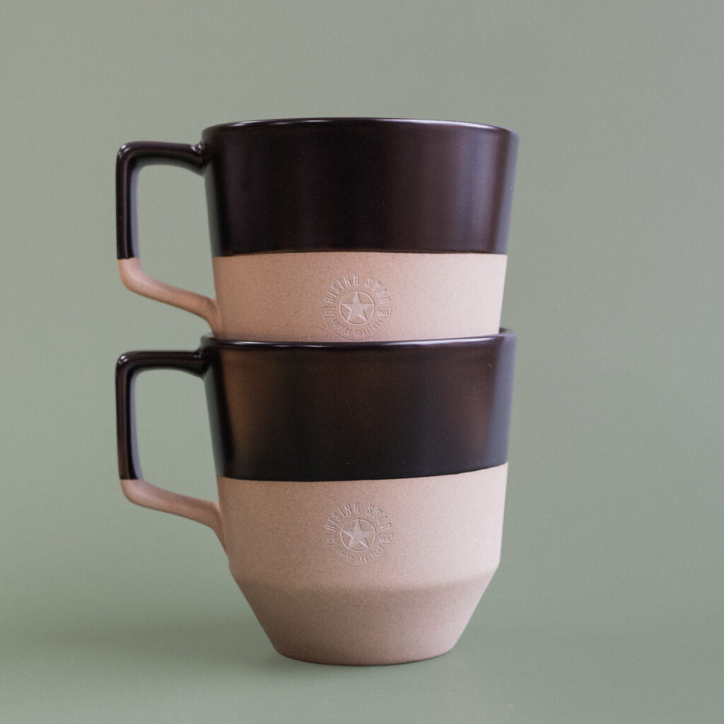 A photo of the stacked black notneutral mugs.