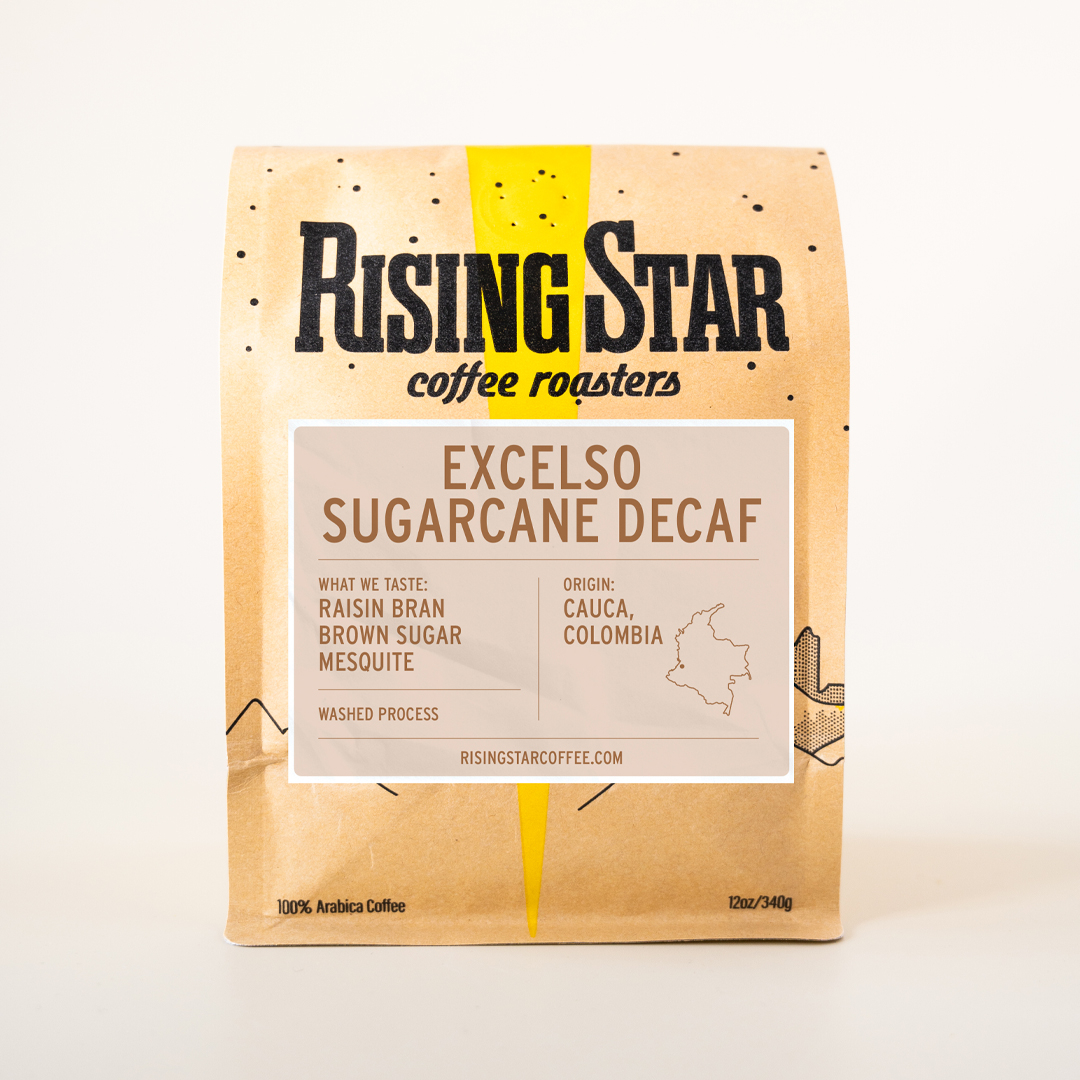 A tan bag of rising star coffee's Excelso Sugarcane Decaf. The label is a cream color with a redish brown text.